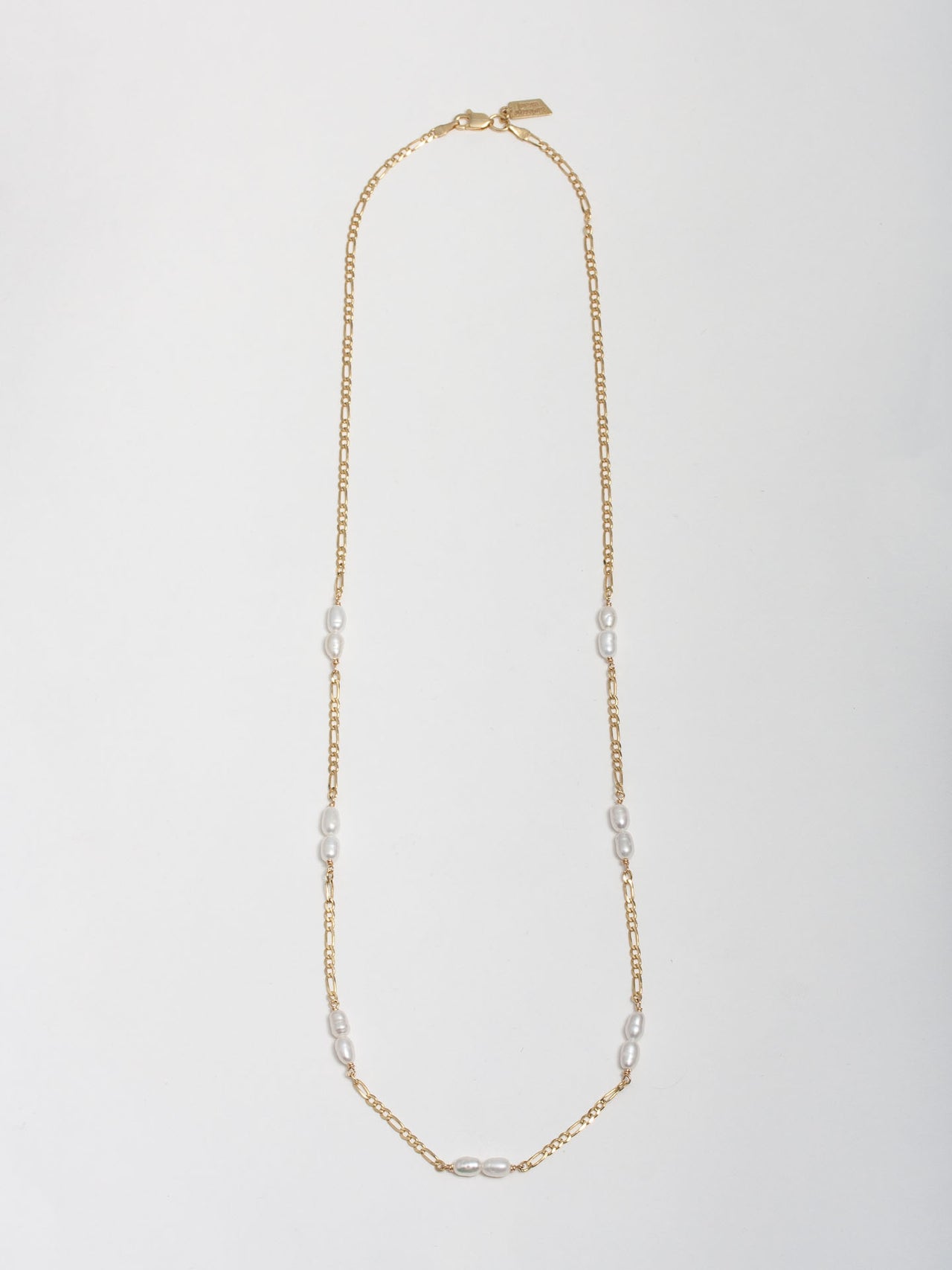 14kt Yellow Gold Figaro & Pearl Strand pictured on light grey background.