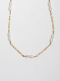 14kt Yellow Gold Figaro & Pearl Strand pictured close up on light grey background.