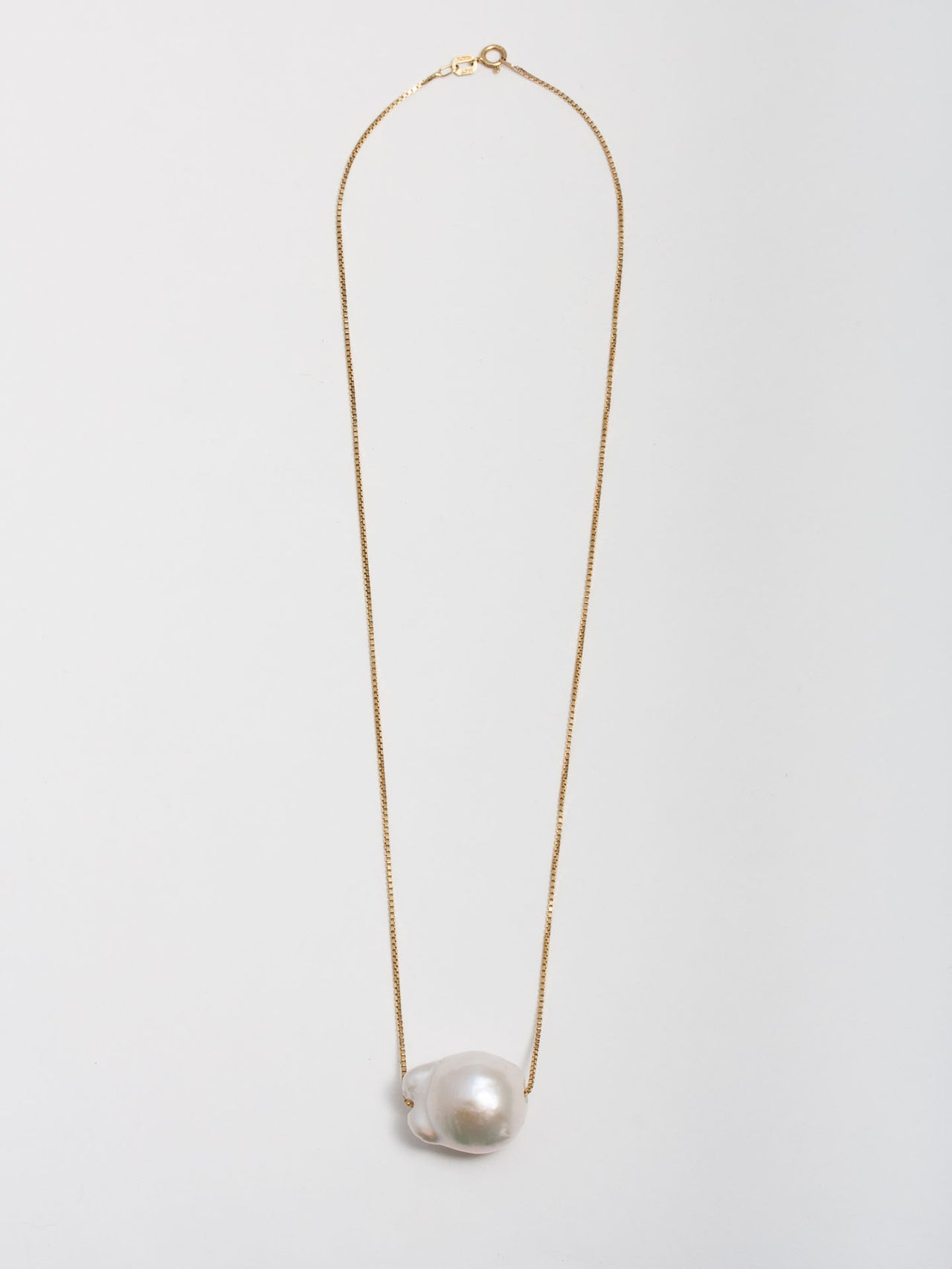 14kt Yellow Gold Baroque Pearl on Fairy Floss Necklace pictured on light grey background. 