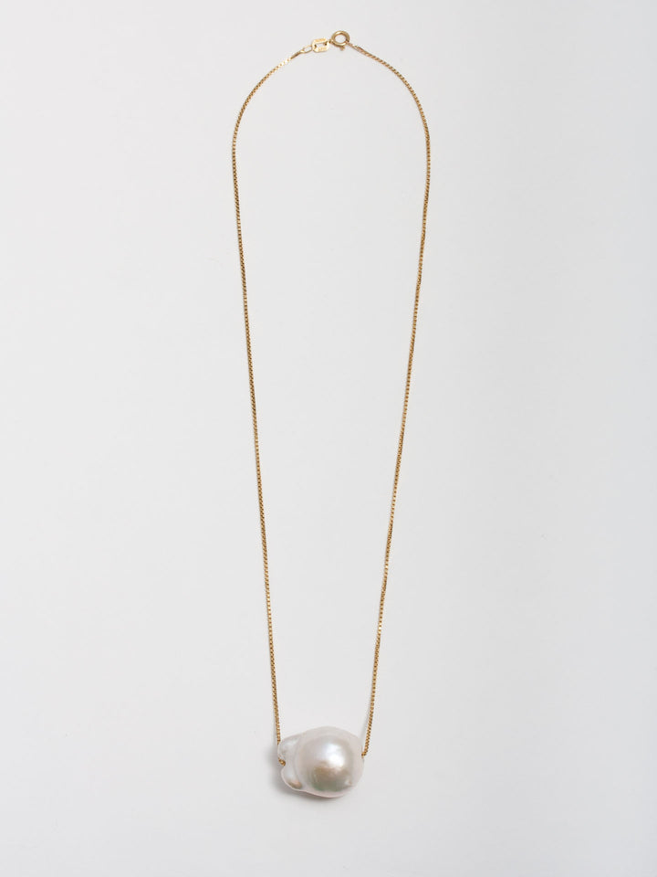 14kt Yellow Gold Baroque Pearl on Fairy Floss Necklace pictured on light grey background. 
