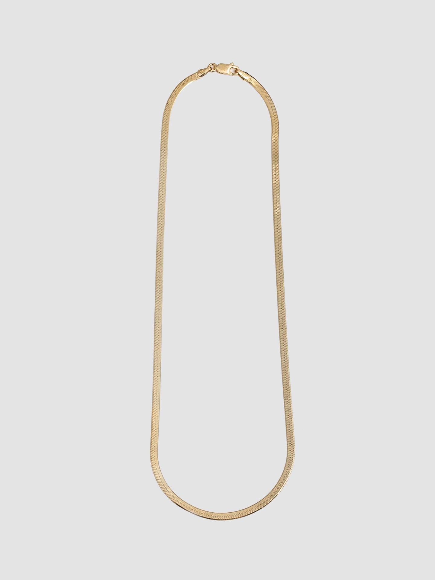 Vermeil Herringbone Chain Necklace pictured on light grey background. 