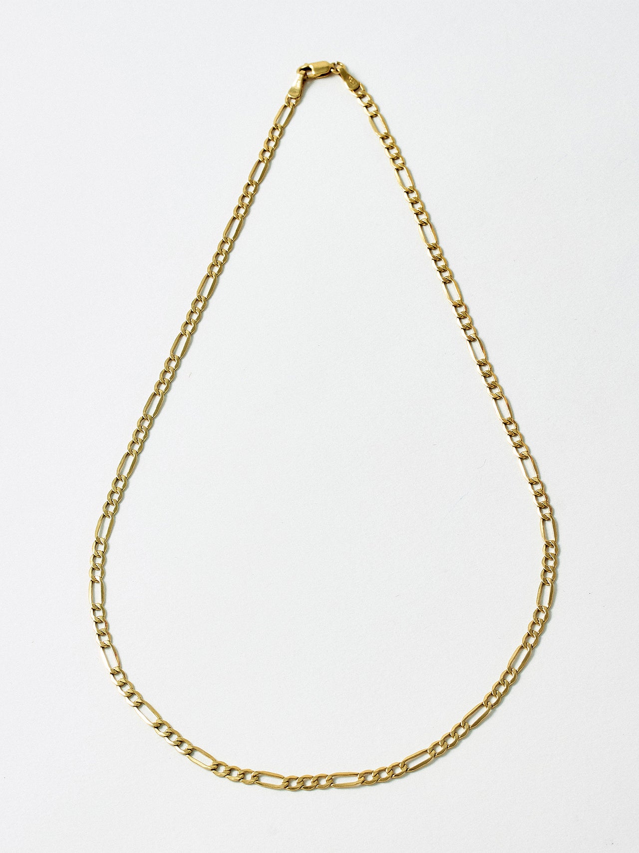 14kt Yellow Gold Hollow Figaro Chain pictured on light grey background.