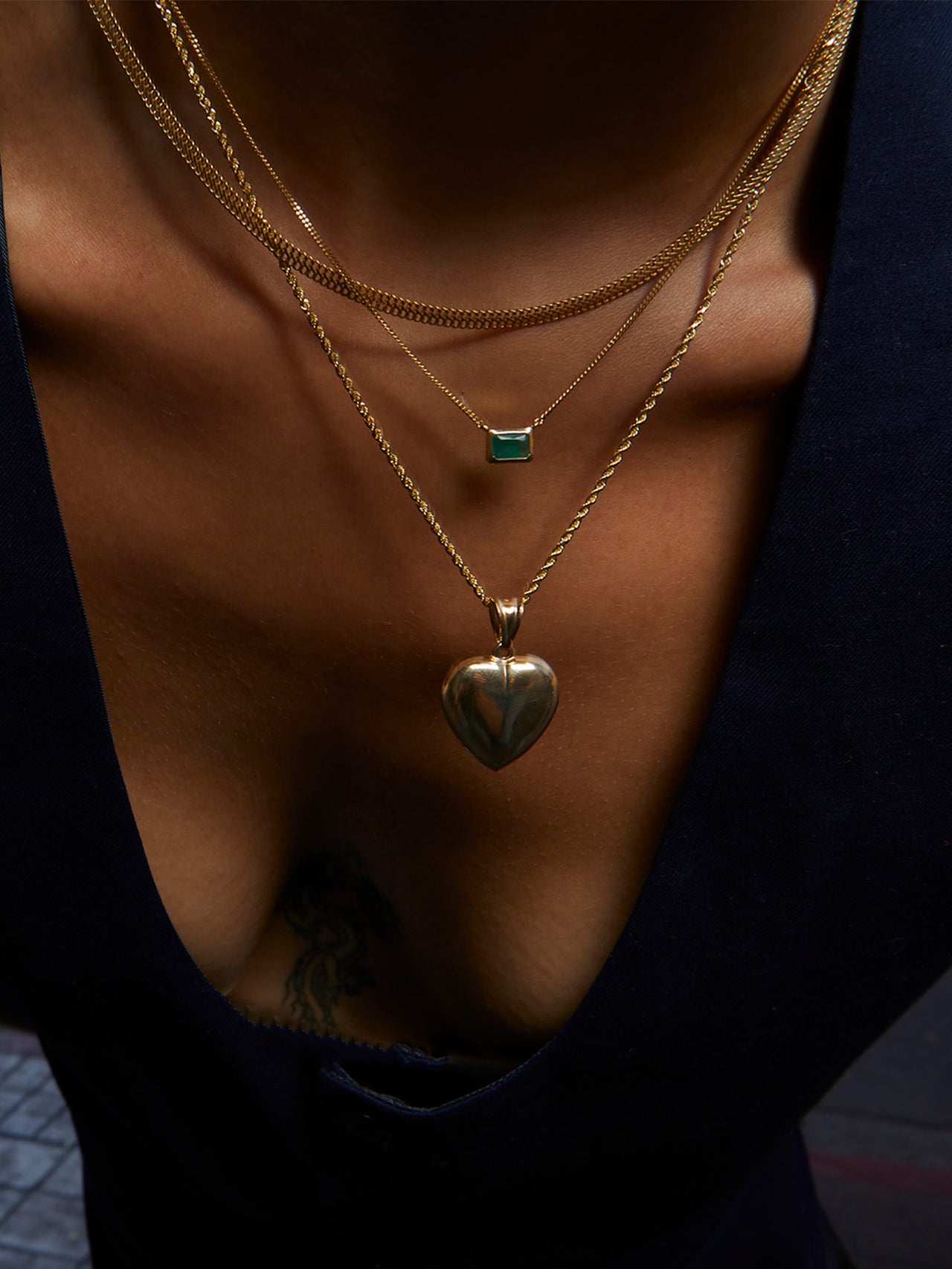 14kt Yellow Gold XL Puff Heart Pendant pictured on model. Strung on Solid Gold Rope Chain. 