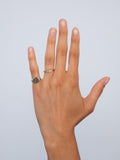 Picture of models hand with the Diamond & Emerald Baby Bands worn on  index finger.