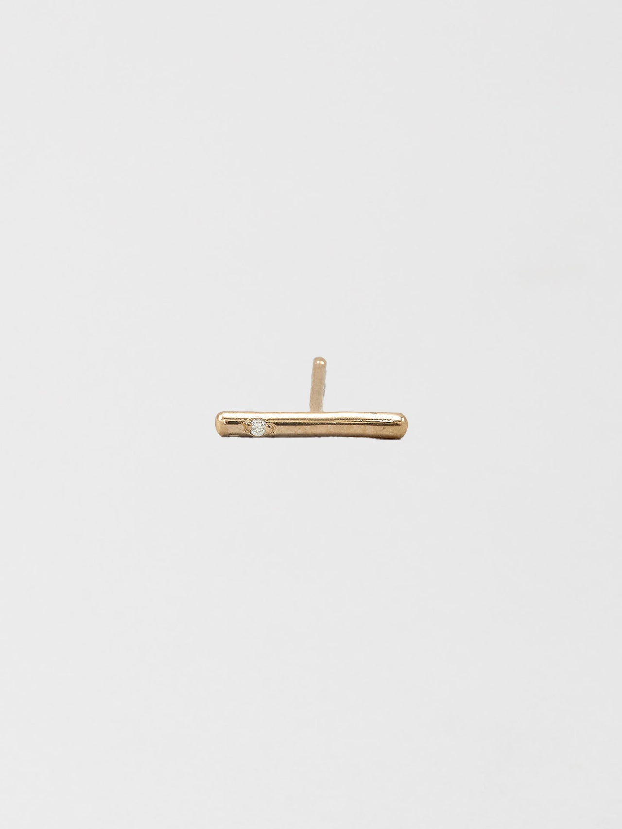 14kt Yellow Gold Solo Diamond Rod Stud Earring pictured on light grey background.
