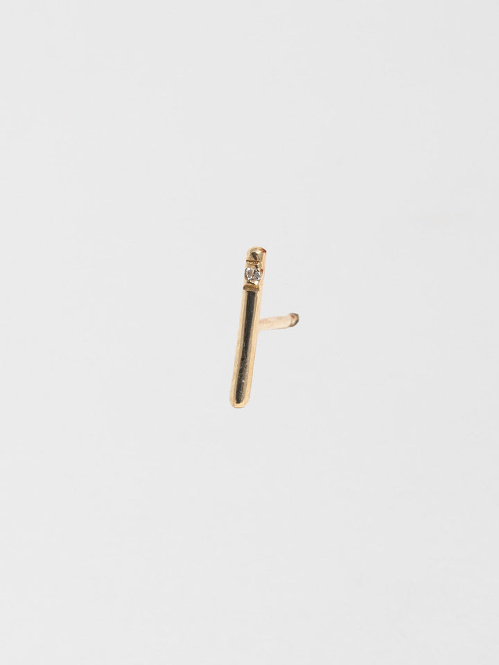 14kt Yellow Gold Solo Diamond Rod Stud Earring pictured on grey background.