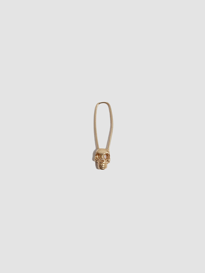 Skull Safety Pin earring on light grey background.