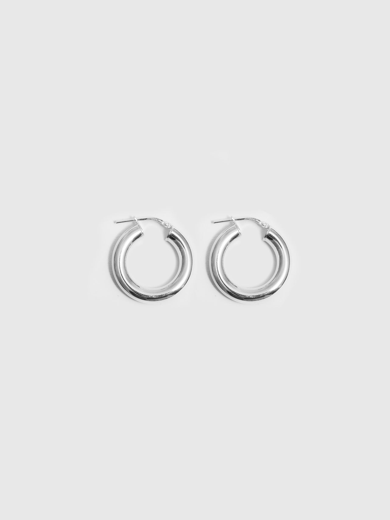 Product shot of thick sterling silver tru hoops shot on white background.