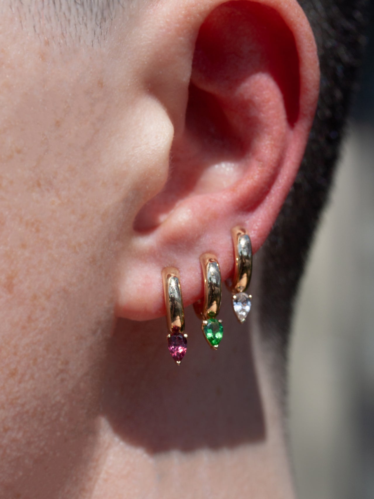 14kt Gold Tsavorite Huggies pictured in second piercing along with White Sapphire and Rhodolite.