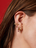 Close up of 14kt Yellow Gold Gemstone Love Stud pictured on model. Red background.