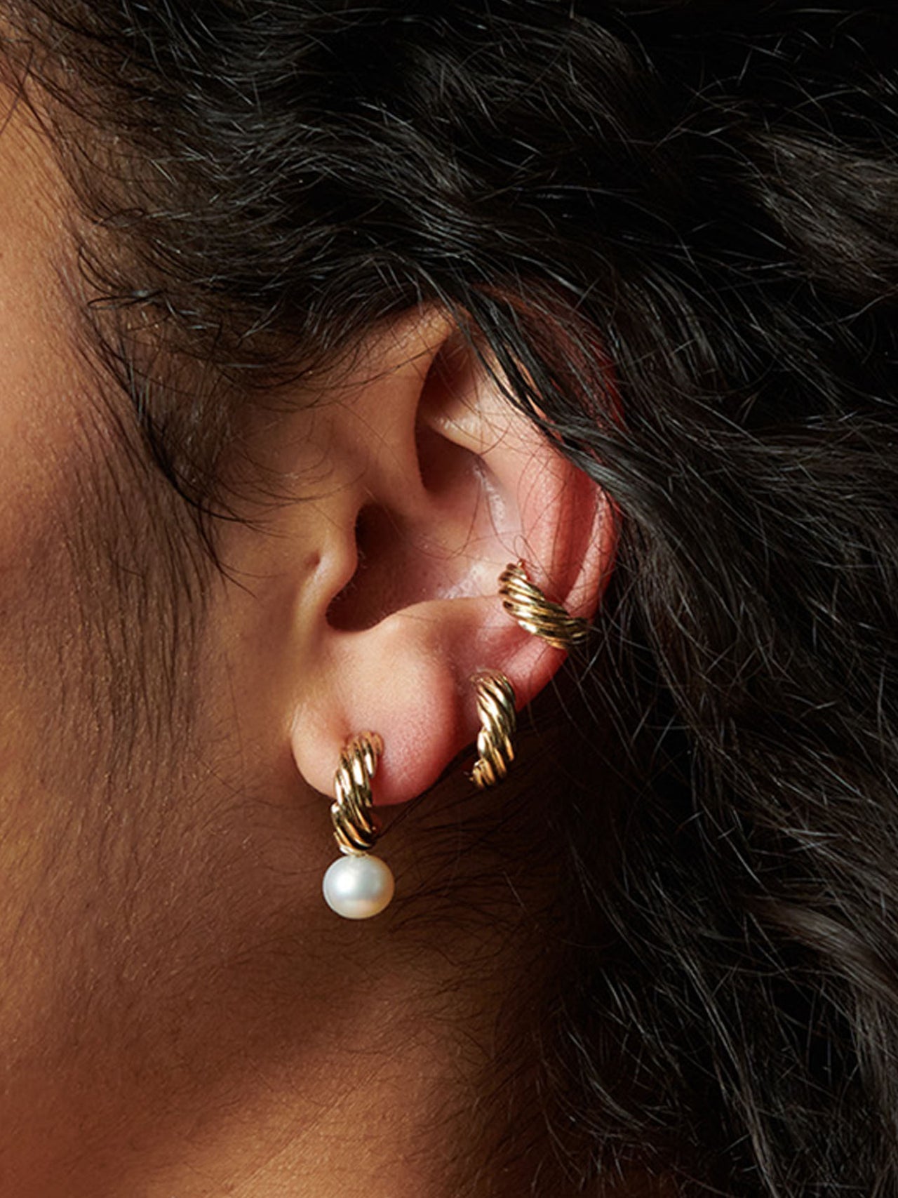 14kt Yellow Gold Lanyard Pearl Hoops pictured on model in first hole on ear lobe. 