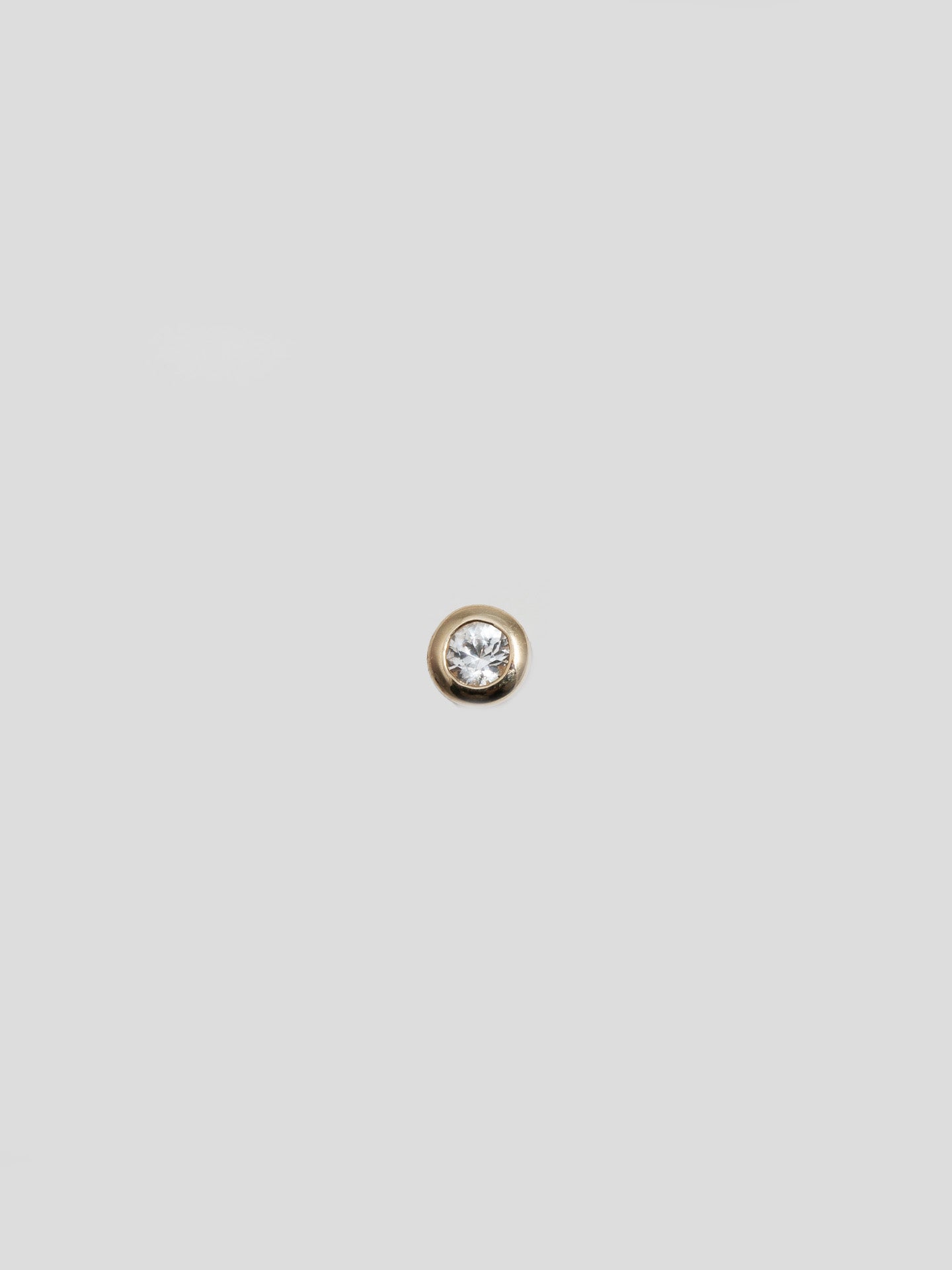 14kt Yellow Gold White Sapphire Bezel Stud pictured solo on light grey background. 