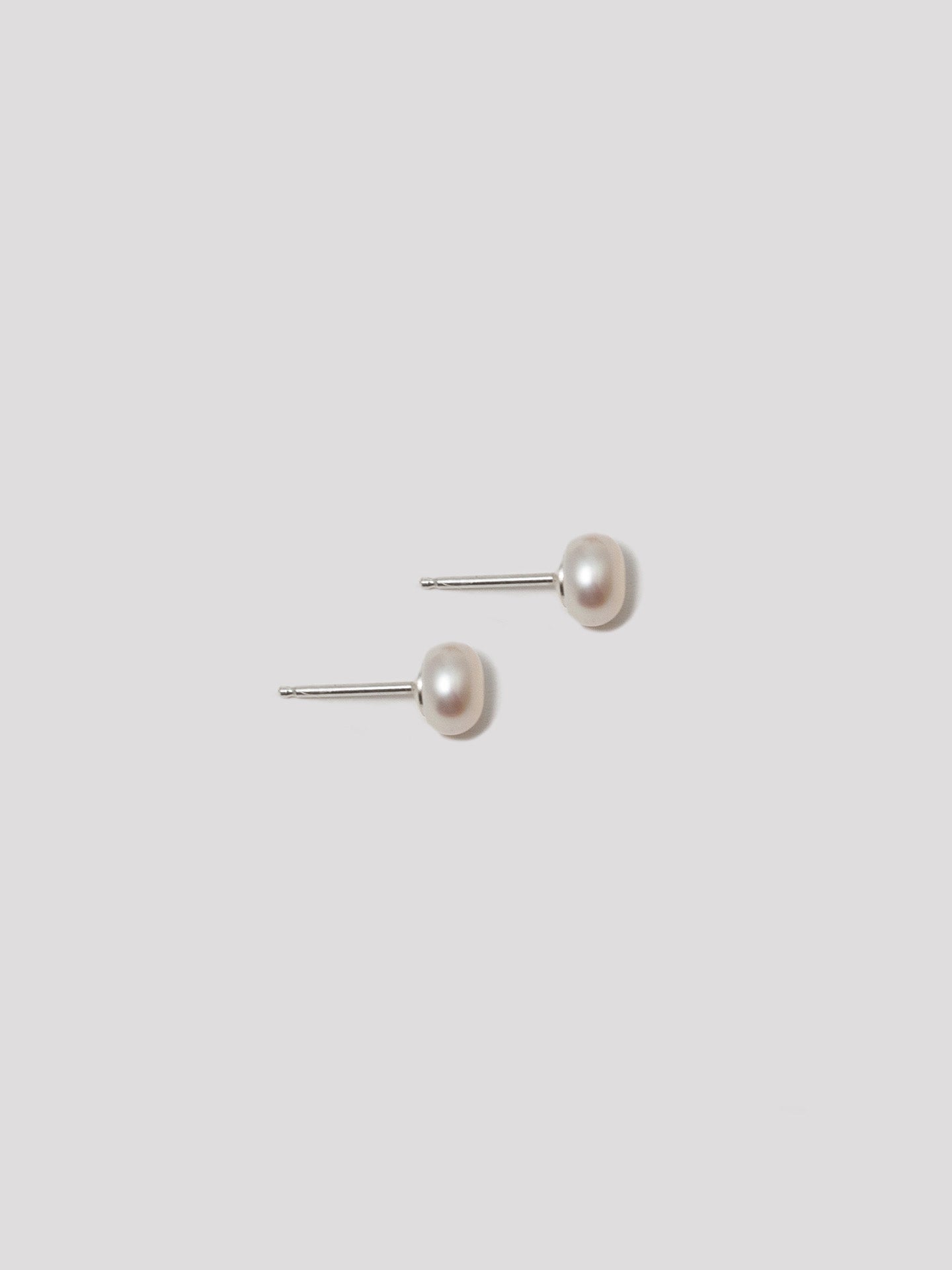 Sterling Silver Freshwater Pearl Studs pictured on light grey background. 