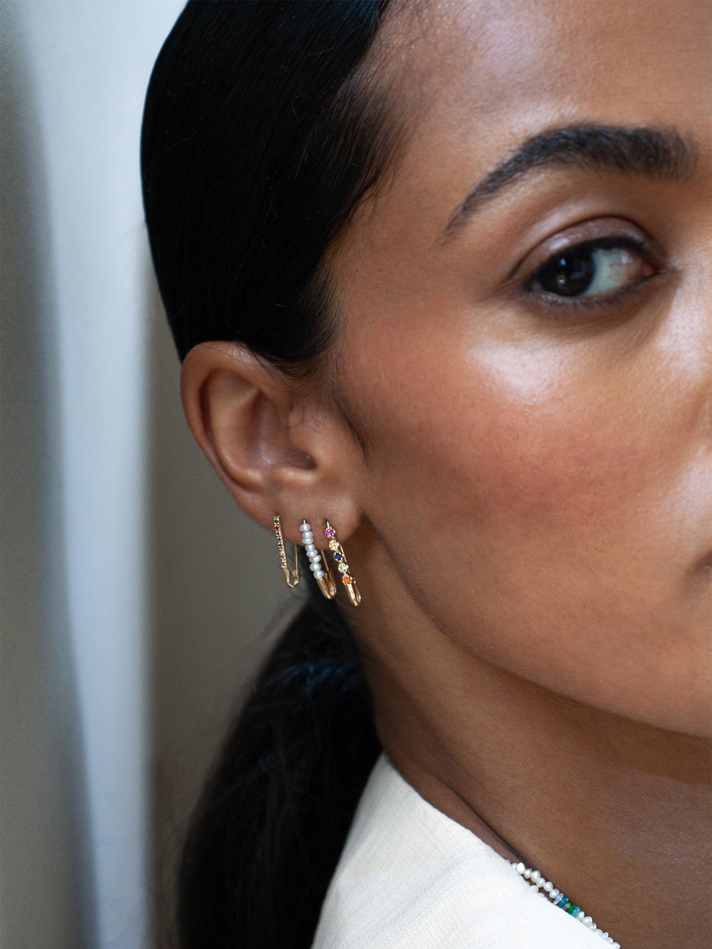 14kt Yellow Gold Sunset Safety Pin pictured in models first piercing. Stacjed along side the Mini Friendship and Mini Rainbow Safety Pin. 