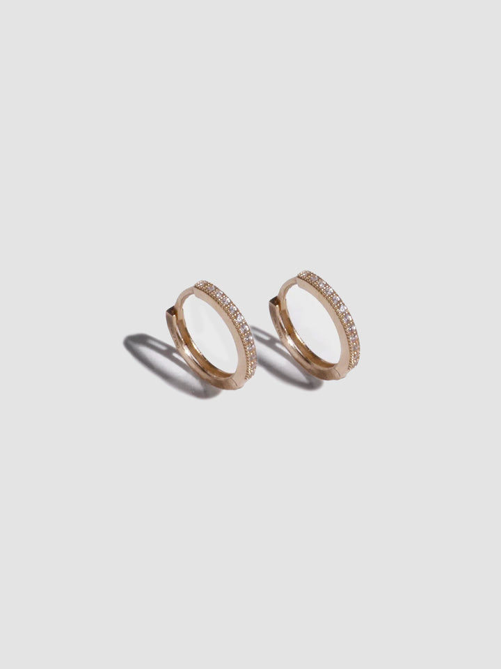 A pair of 14kt yellow gold pave hoop earrings with cubic zirconia, displayed against a white background.