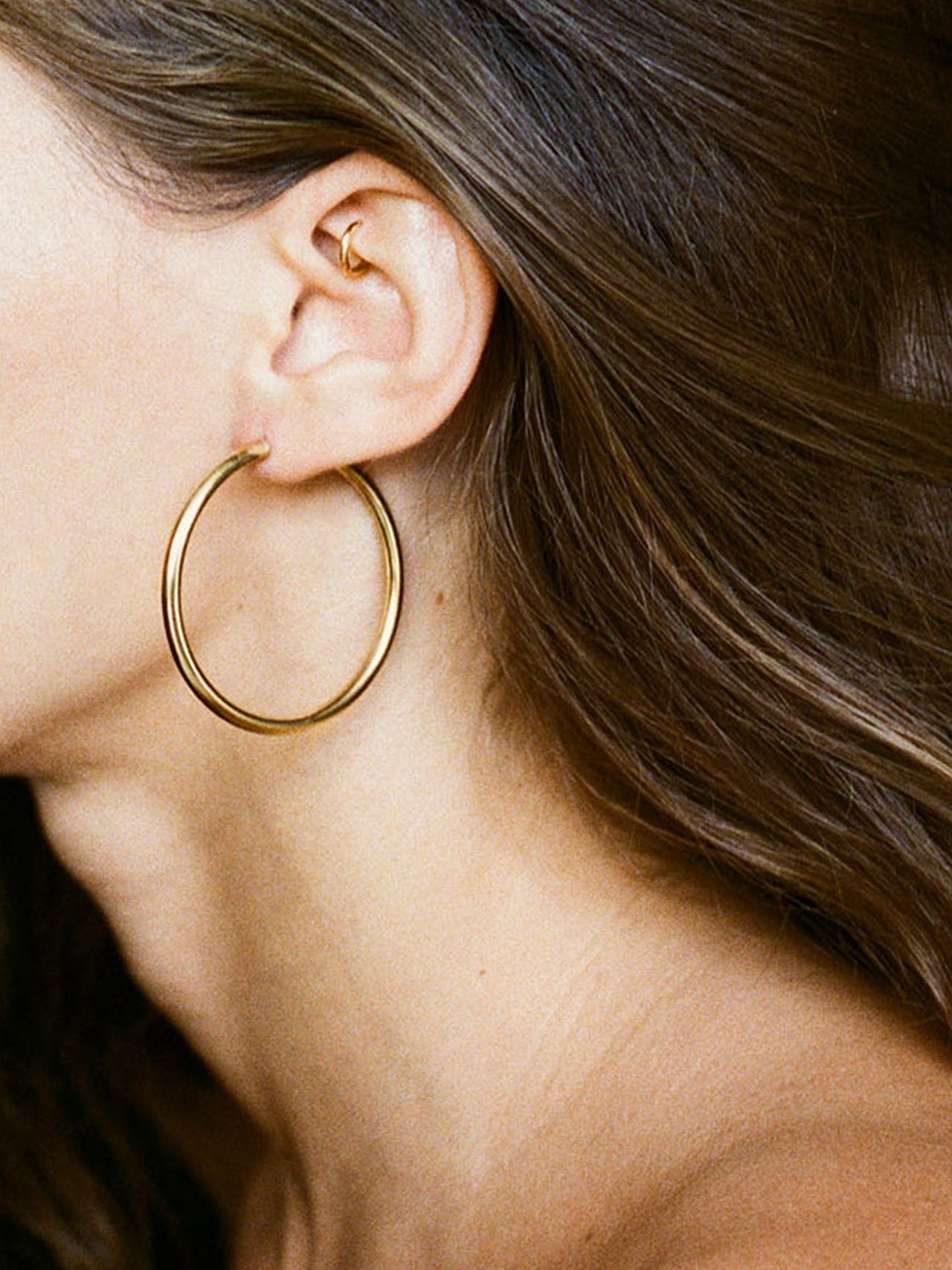 14Kt Yellow Gold Tube Hoops pictured on model.