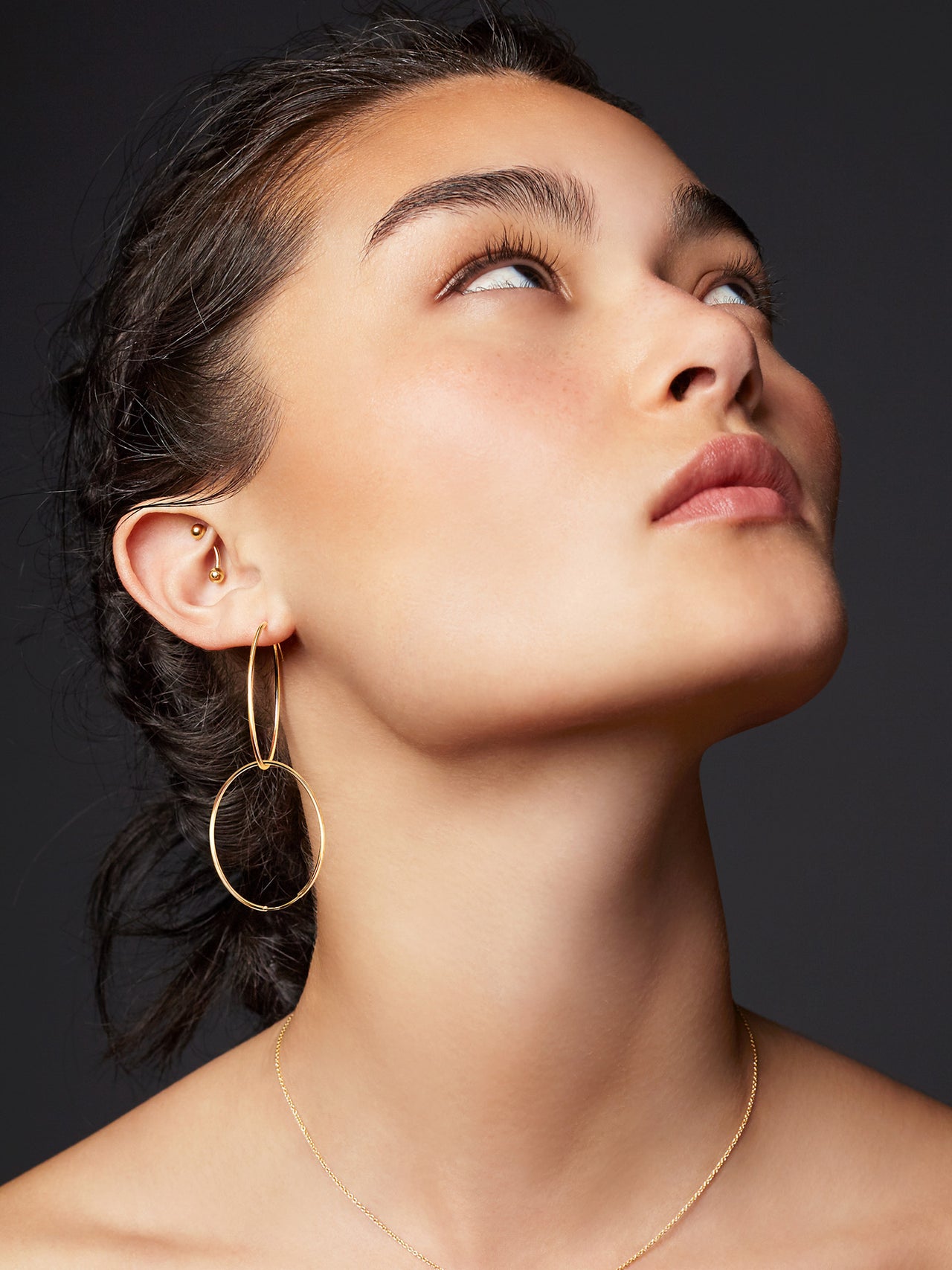 14Kt Yellow Gold Ultralight Infinity Hoops pictured on model. Two hoops connected.