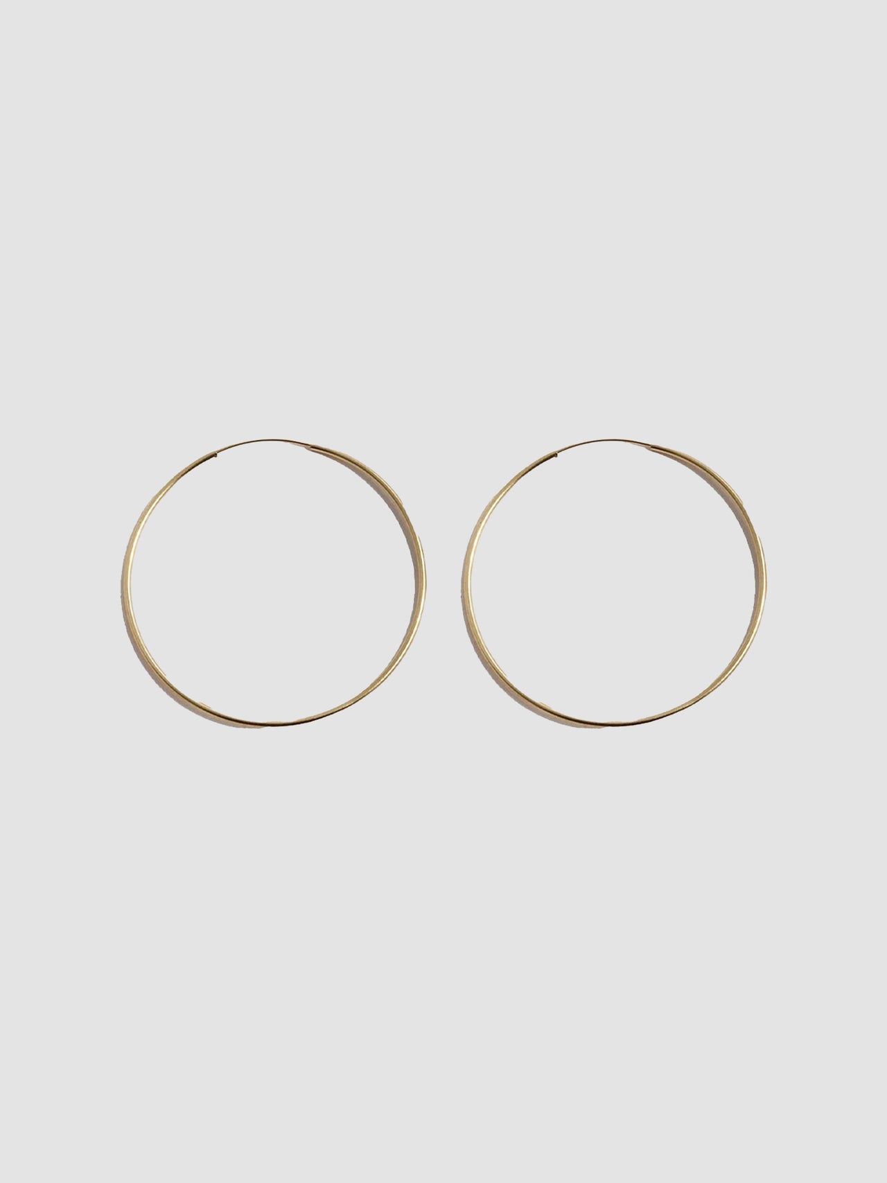 14kt Yellow Gold Ultralight Infinity Hoops  shot on light grey background.