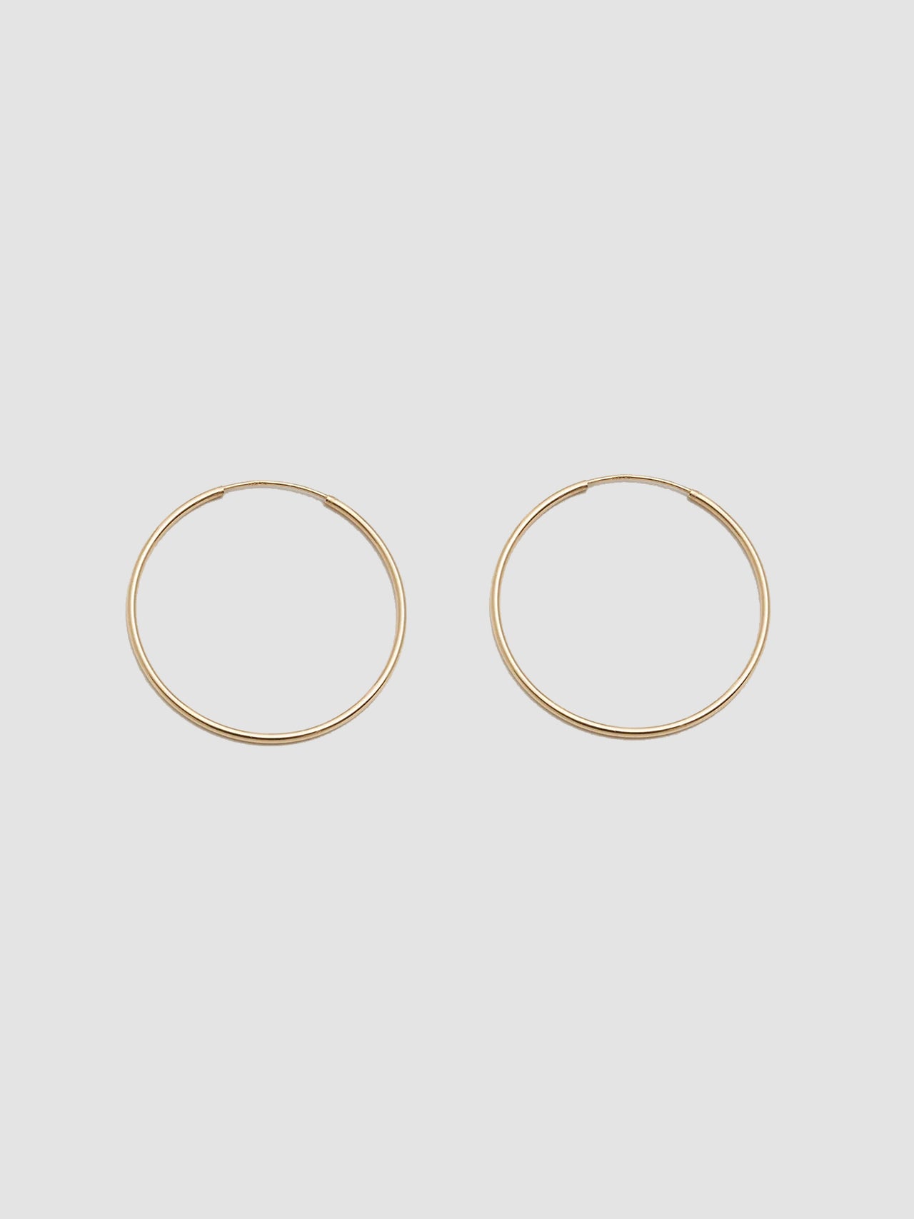 Product shot the Winona Hoops ( 14Kt Yellow Shiny Gold Hoops) Background: Grey paper 