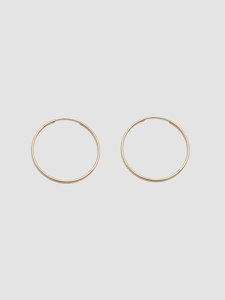 Product shot the Winona Hoops ( 14Kt Yellow Shiny Gold Hoops) Background: Grey paper 