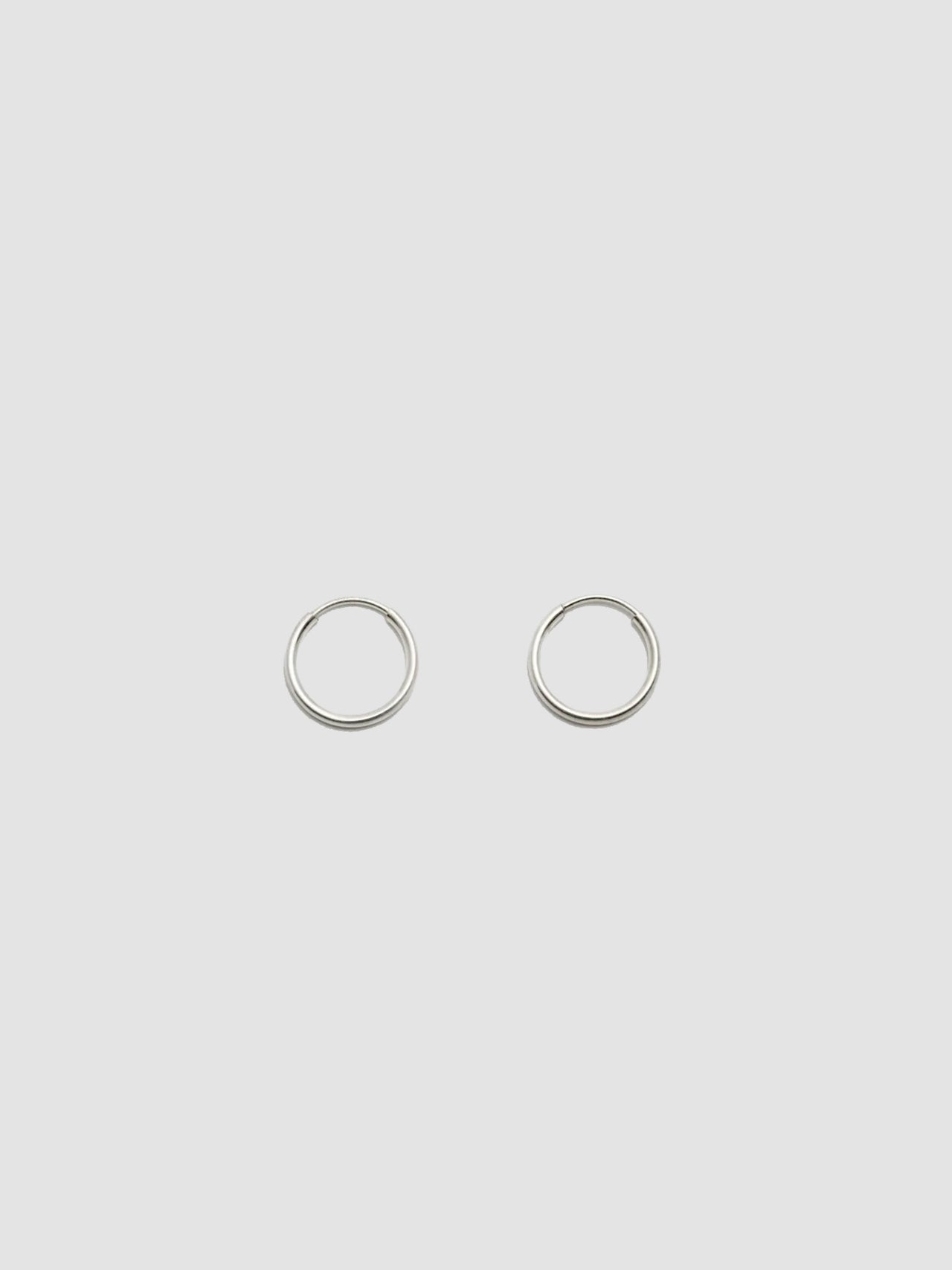 A pair of sterling silver hollow infinity hoop earrings on a white background.