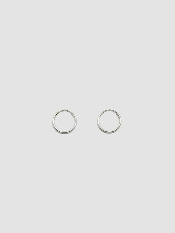 A pair of sterling silver hollow infinity hoop earrings on a white background.