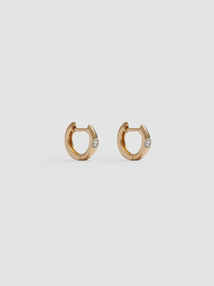 Product shot of the Solo Sparkle Huggies (14kt Yellow Gold 7.7mm Diameter 1.7mm Wide 1.11gr) Background: Grey Backdrop