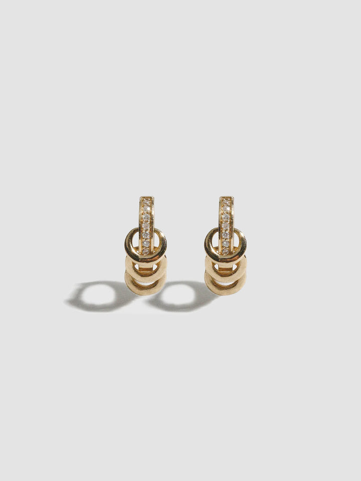 Pair of gold earrings with diamond accents on a light gray background