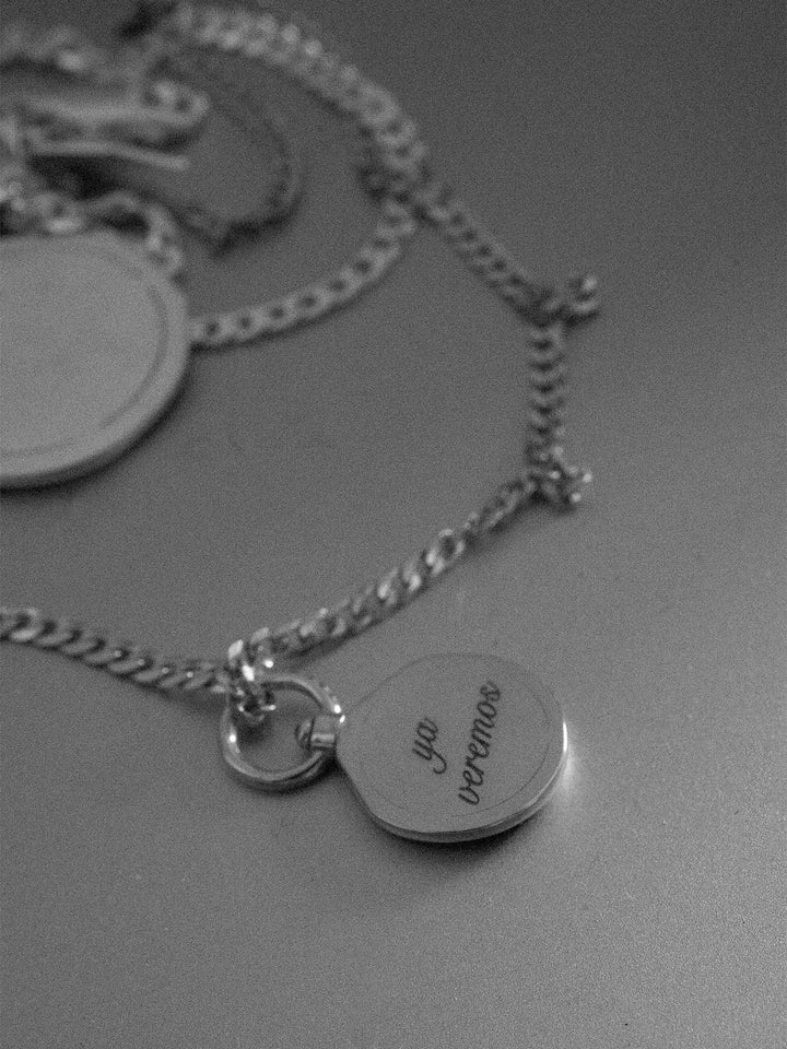 Silver necklace with pendant on a gray surface