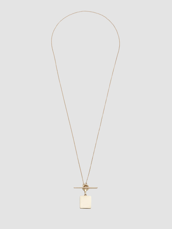 Gold necklace with a pendant on a light gray background