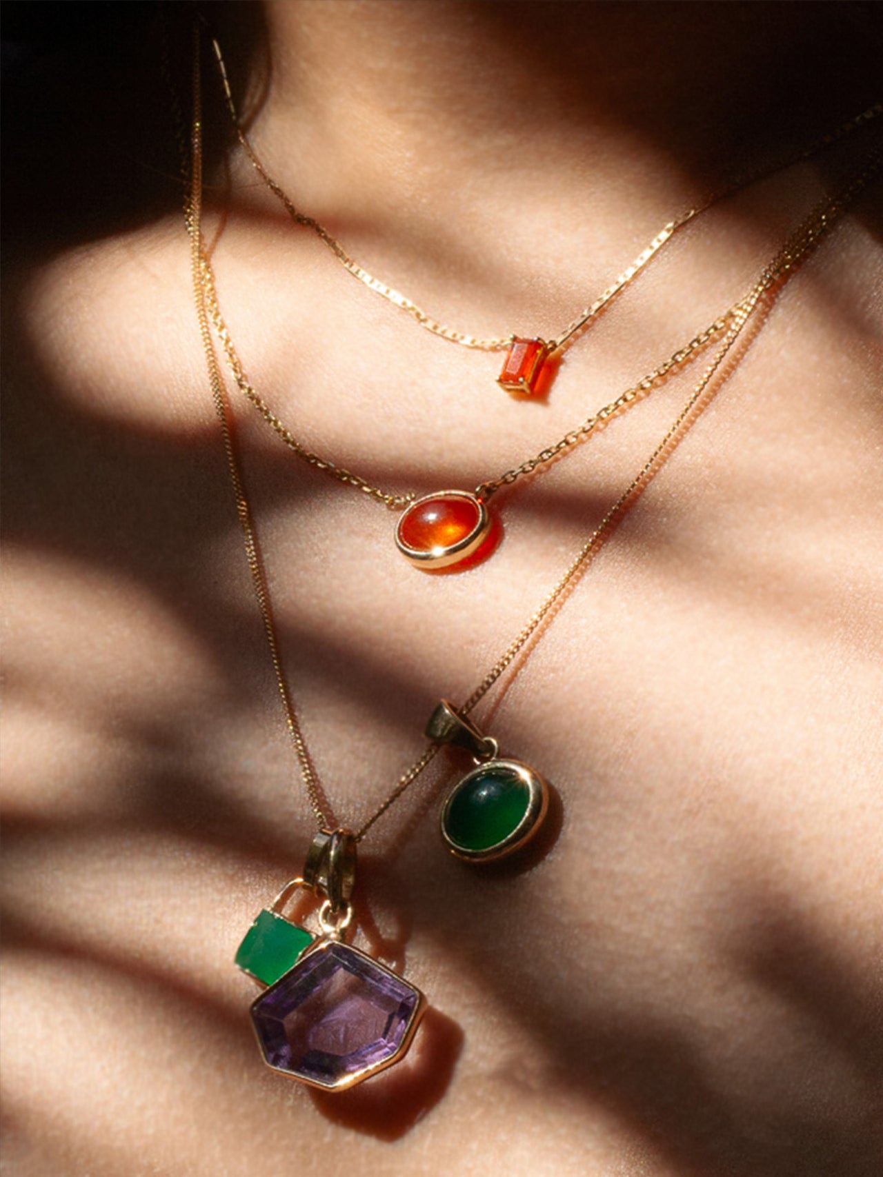 Close up shot of Fire Opal Cabochon Necklace in the sunlight on model.