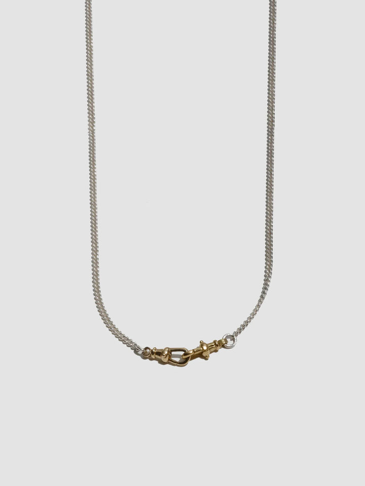 Necklace with a gold clasp on a light gray background