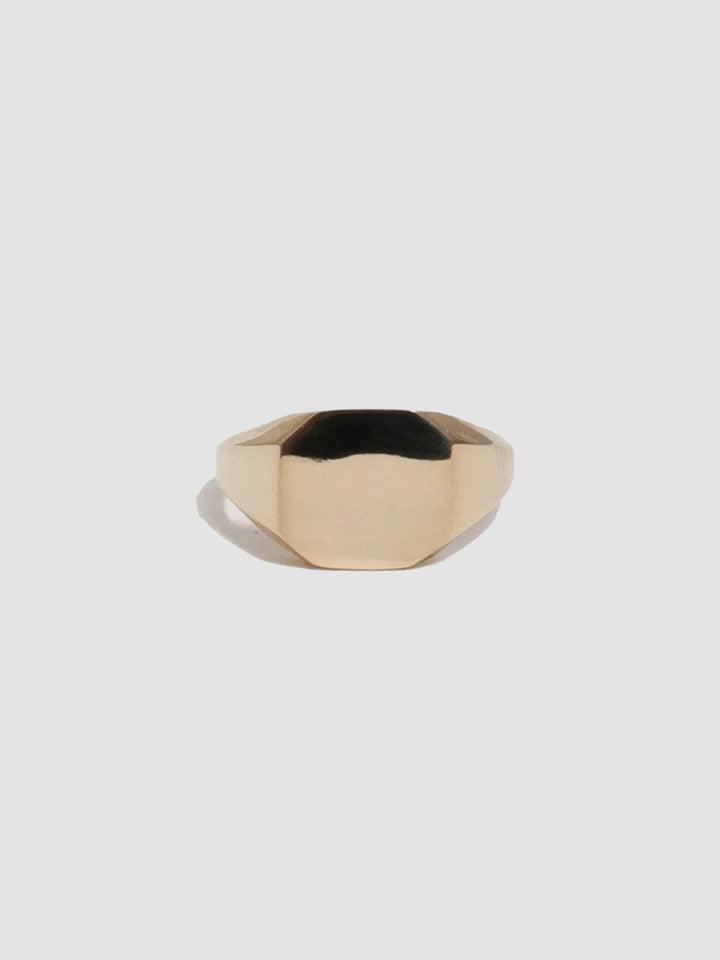 Gold ring on a light gray background
