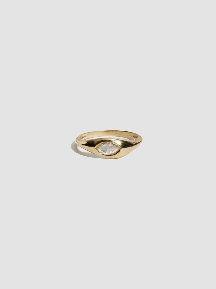 Gold ring with a diamond on a light gray background