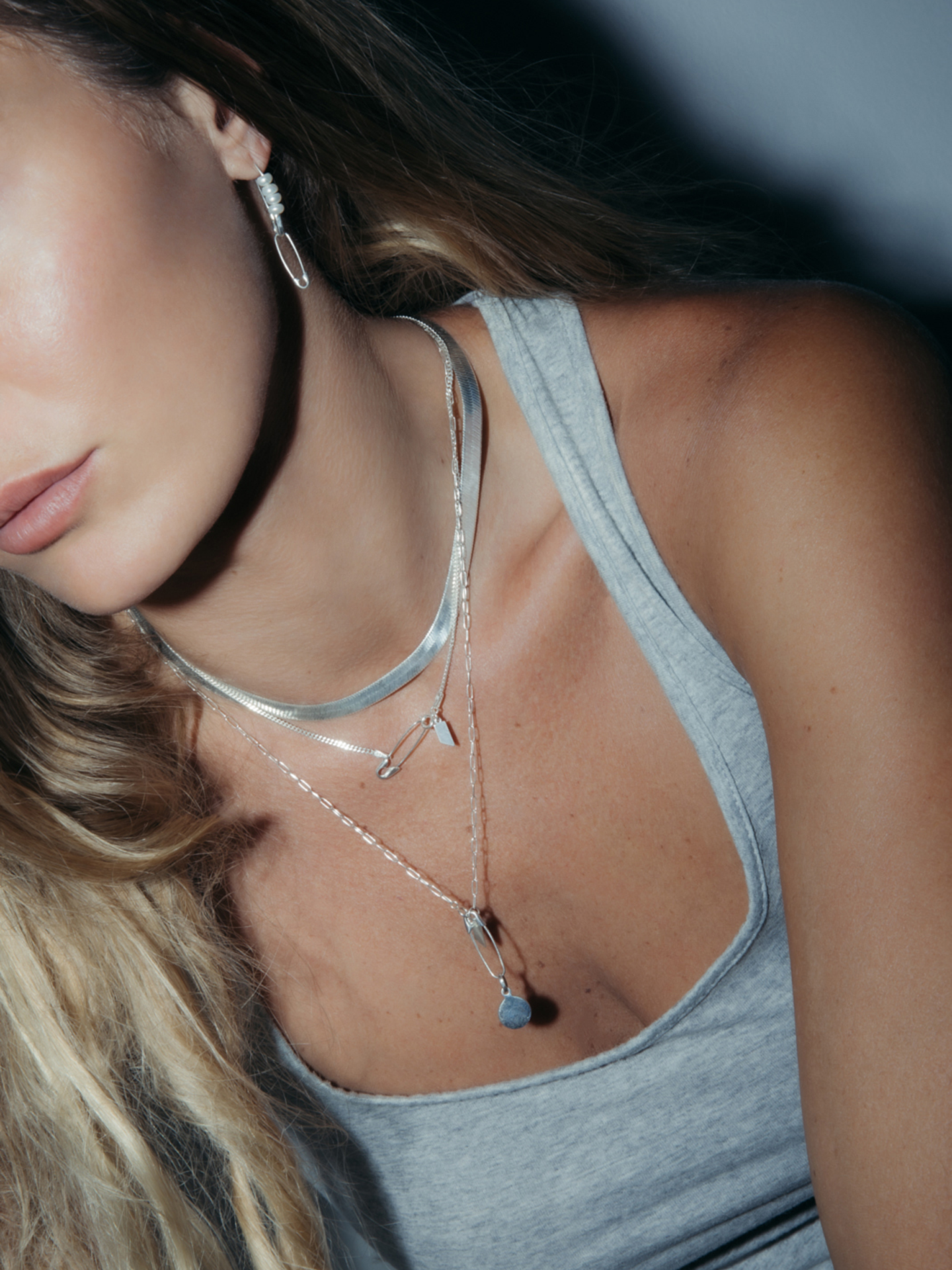 Sterling Silver Safety Pin Earring pictured as a charm holder and necklace extender. Model is wearing the Sterling Silver XL Herringbone Necklace (16"), Petite Havana Chain (18"), and the 