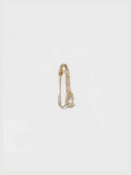 Gold safety pin earring on a light gray background