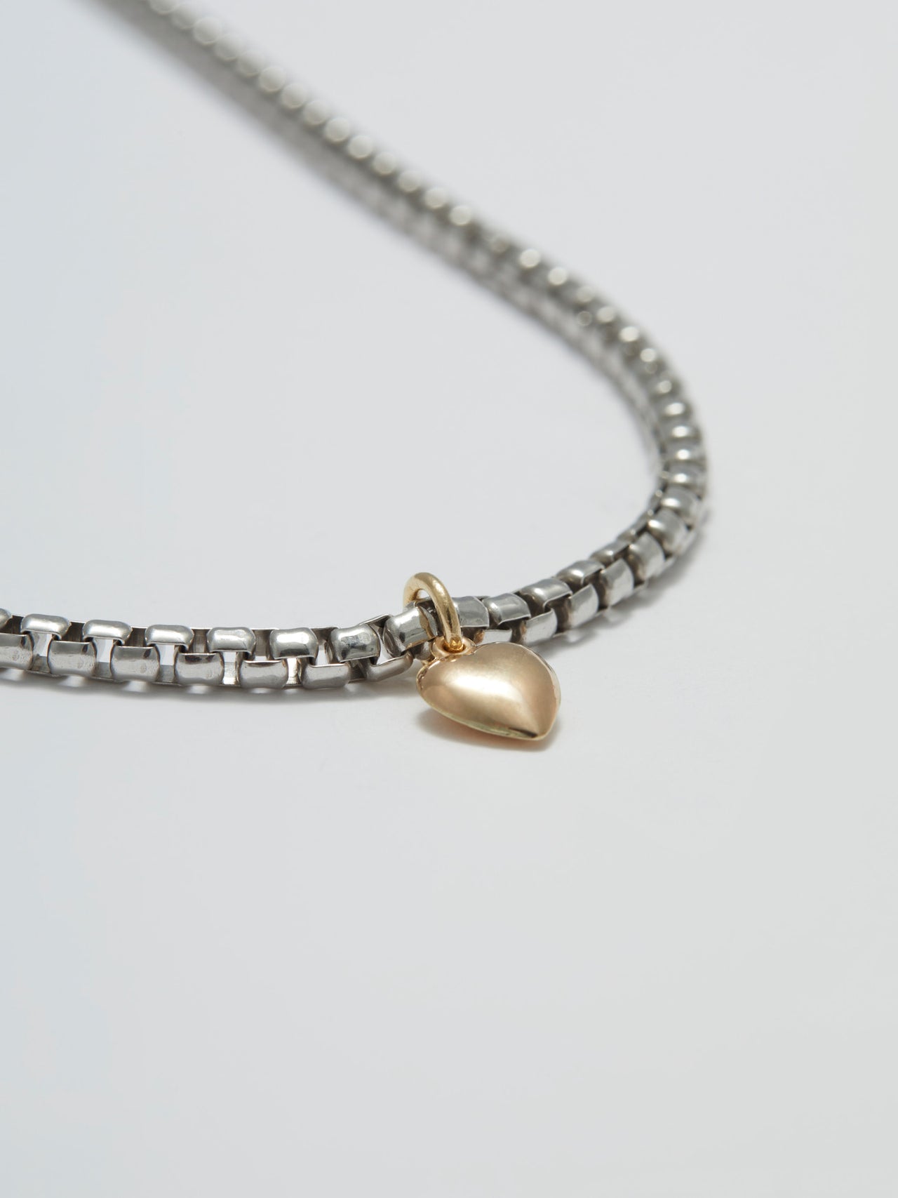 Close  up of Gordita Necklace: Sterling Silver Round Box Chain with 14kt Yellow Gold Puff Heart Pendant