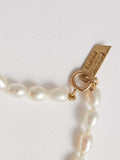 Product shot of White Rice Pearl Anklet including logo and closure. Light grey background.
