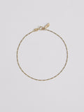 Product shot of the Baby Fig Chain Anklet (10kt Yellow Gold Figaro Chain Width: 1.3mm Thickness: 0.5mm Length: 10") Background: Grey backdrop