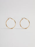 Product shot of the Legacy Hoops (14kt Yellow Gold 5mm Wide 30mm Diameter) Background: Grey backdrop