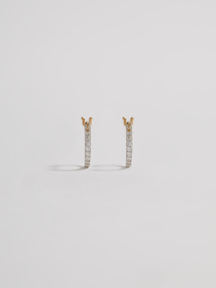 Product shot of the Petite Pave Huggies (14KT Yellow Gold 10mm Diameter 1.1mm CZ) Background: Grey backdrop