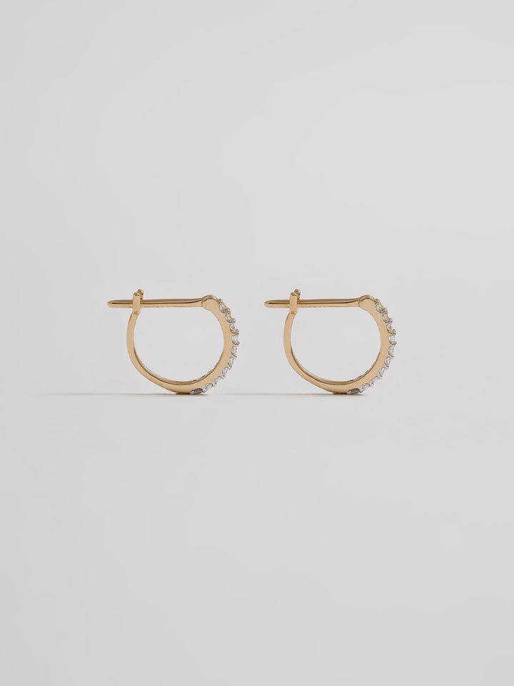 Product shot of the Petite Pave Huggies (14KT Yellow Gold 10mm Diameter 1.1mm CZ) Background: Grey backdrop