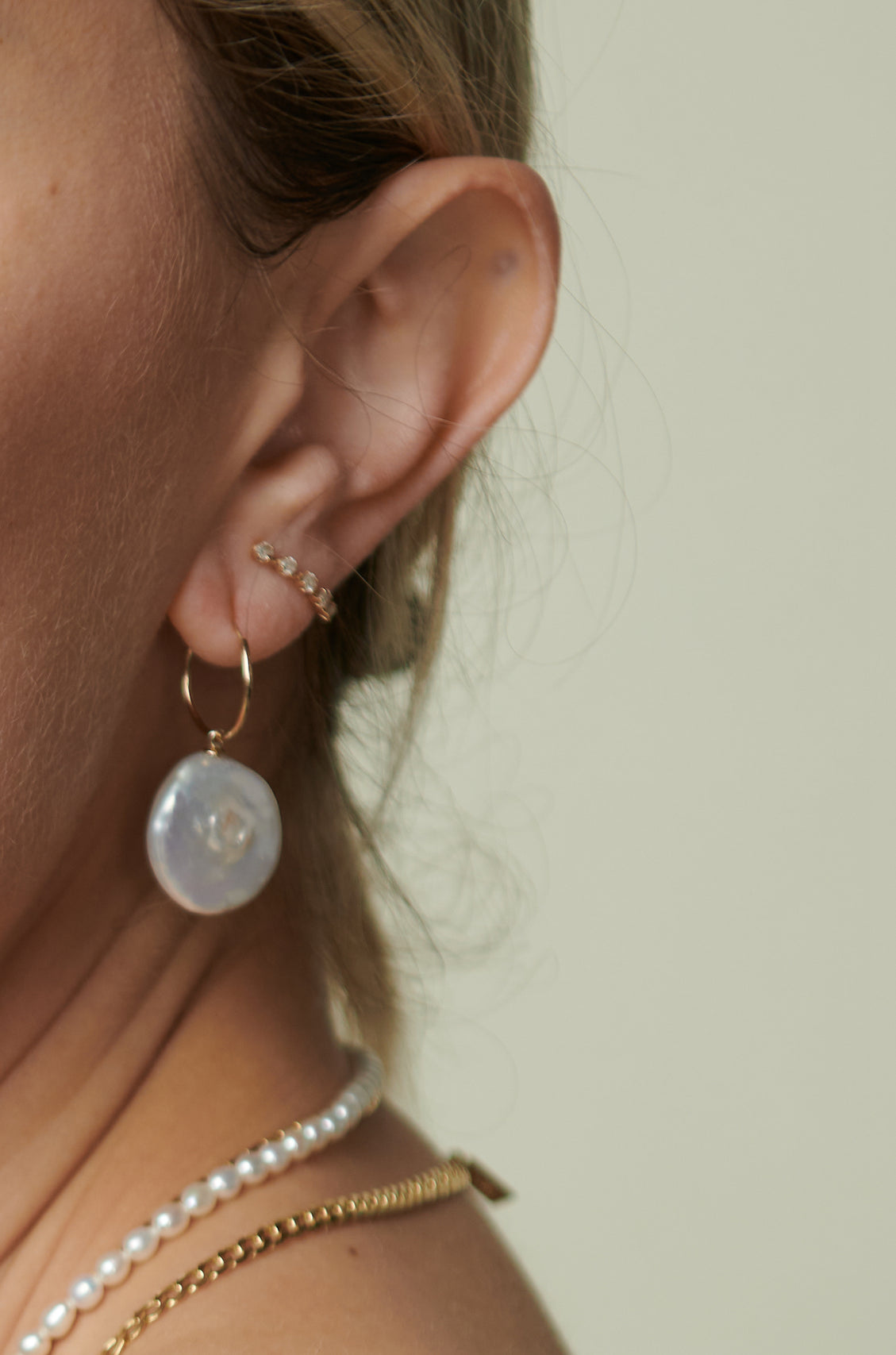 14Kt Yellow Gold Infinity Freshwater Baroque Pearl Earrings pictured on models ear.