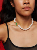 14kt Yellow Gold Toggle Jade Pearl Necklace pictured on model. Red background. 