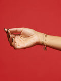 Vermeil ID Tennis Bracelet pictured from backside on models wrist. Red background.