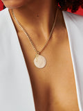 14kt Yellow Gold Hollow XXL Havana Chain Necklace pictured with XL Disk and Key Pendant. Red background.