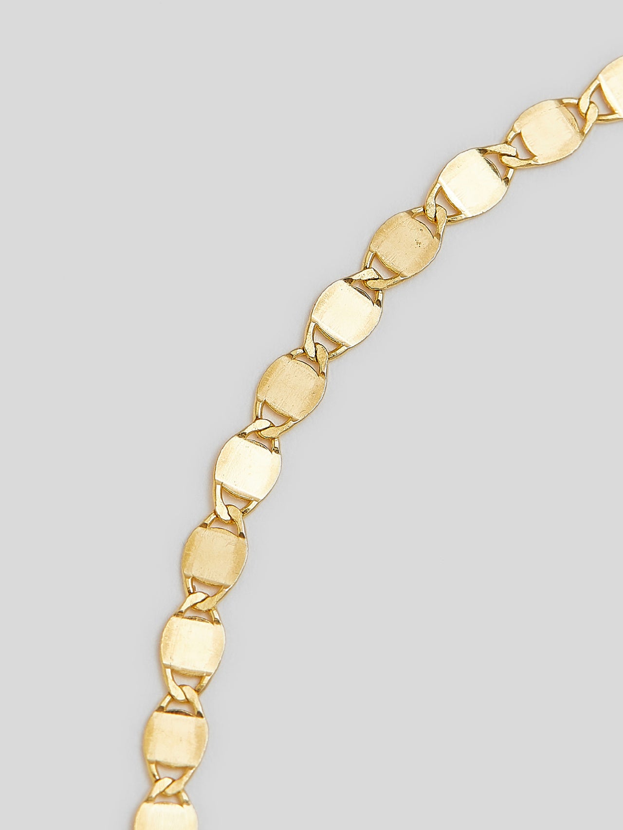 Close up of chain on Product image of 14kt yellow gold valentino chain bracelet on white background. 