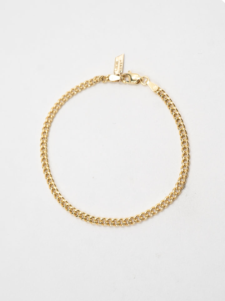 14kt Yellow Gold Curb Chain Bracelet pictured on light grey background. 