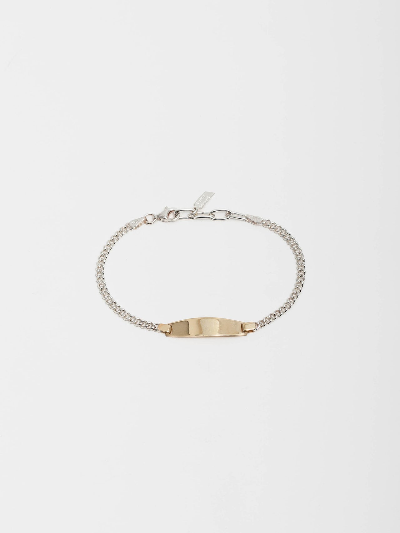 Mini Ellipse Bracelet pictured on light grey background. Sterling Silver Curb Chain with 14kt Yellow Gold Oval ID.