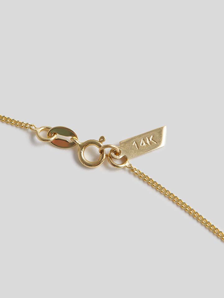 Close up of clasp on Product shot of Necklace with thin yellow gold chain and blue rectangle topaz pendant. Shot on white background.   